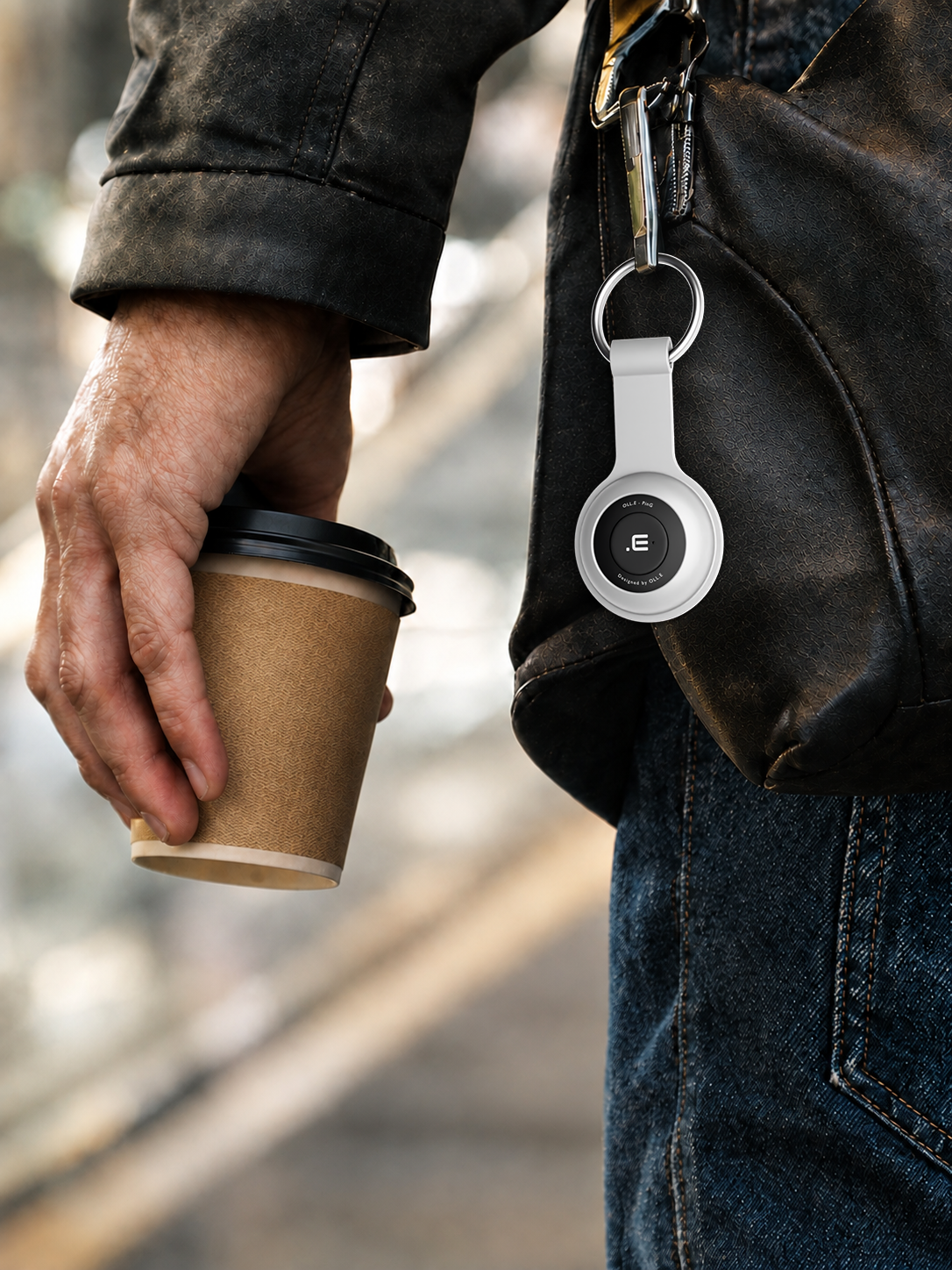 Goes where you go — a Navy PinG clipped to the zip of a shoulder bag on a city street